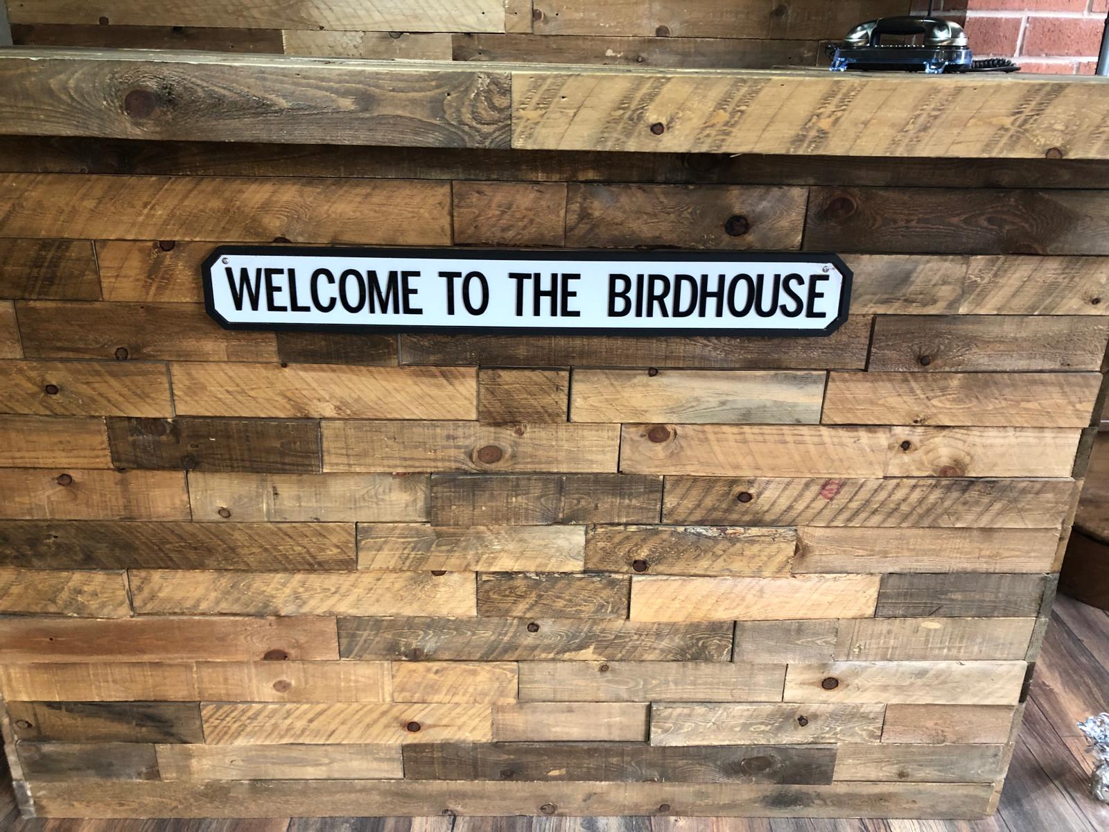 The birdhouse hair room from desk, with a close up of the 'Welcome to the Birdhouse sign.